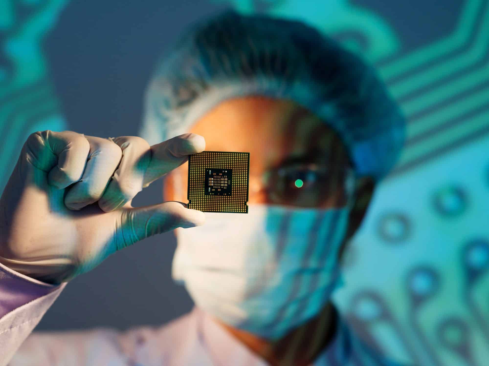 A person in a mask, gloves, and hair cover holds up a microchip, with a circuit board pattern projected in the background—highlighting innovation in the Chemicals and Process industry.