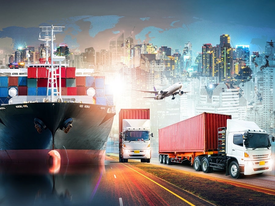 A cargo ship, trucks, and an airplane depict global logistics and transportation, with a city skyline in the background—ideal imagery for Transportation and Logistics executive search professionals.