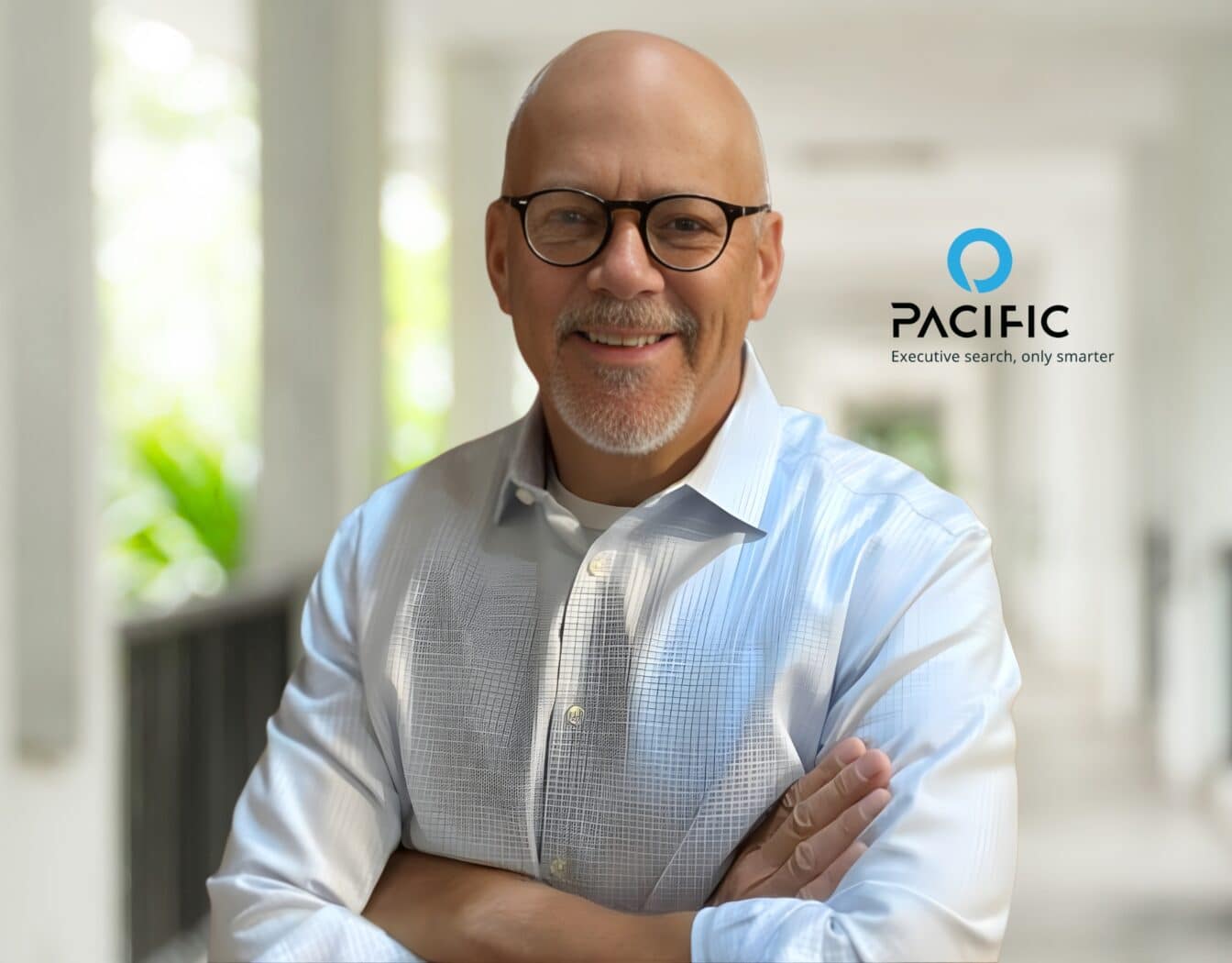 A man wearing glasses and a light blue shirt stands with arms crossed in a bright corridor. The Pacific company logo, slogan, and Advisory Board mention appear beside him.